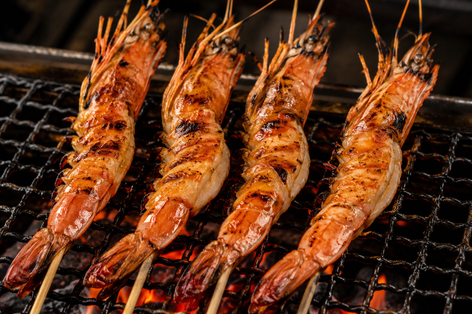 Four grilled prawns on a barbeque